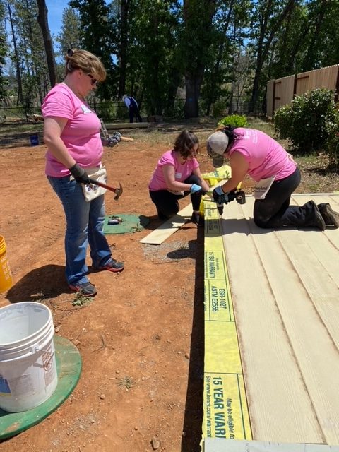 Women using tools and working together to build a home.